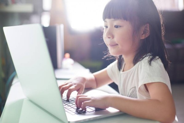 Child with laptop, typing on laptop