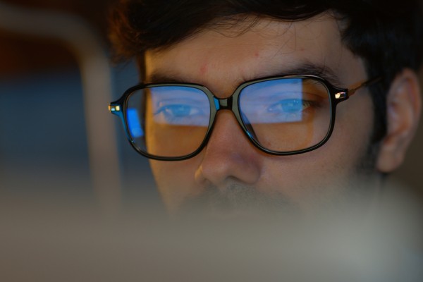 Employee wearing glasses reflecting computer screen