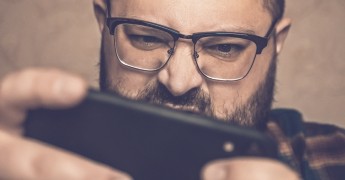 Man looking at smartphone screen, online safety bill