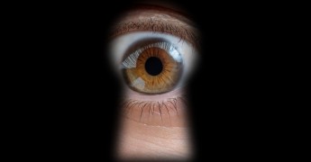 Surveillance, eye lookinh through keyhole
