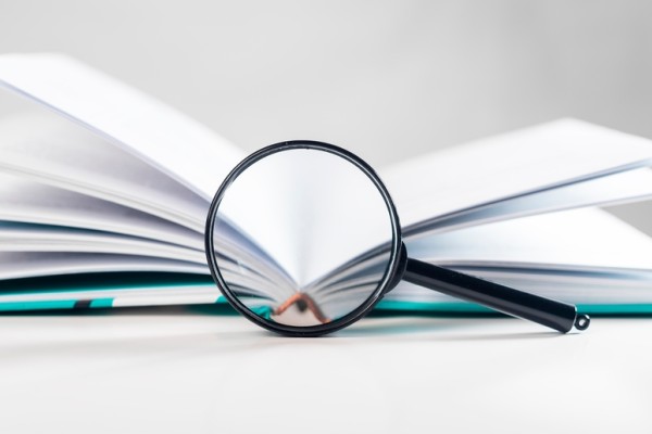 Open book, magnifying glass, transparency