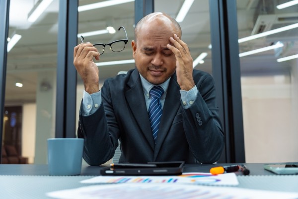 Businessman with head in hands, distrught, worried, sales, blog, course materials